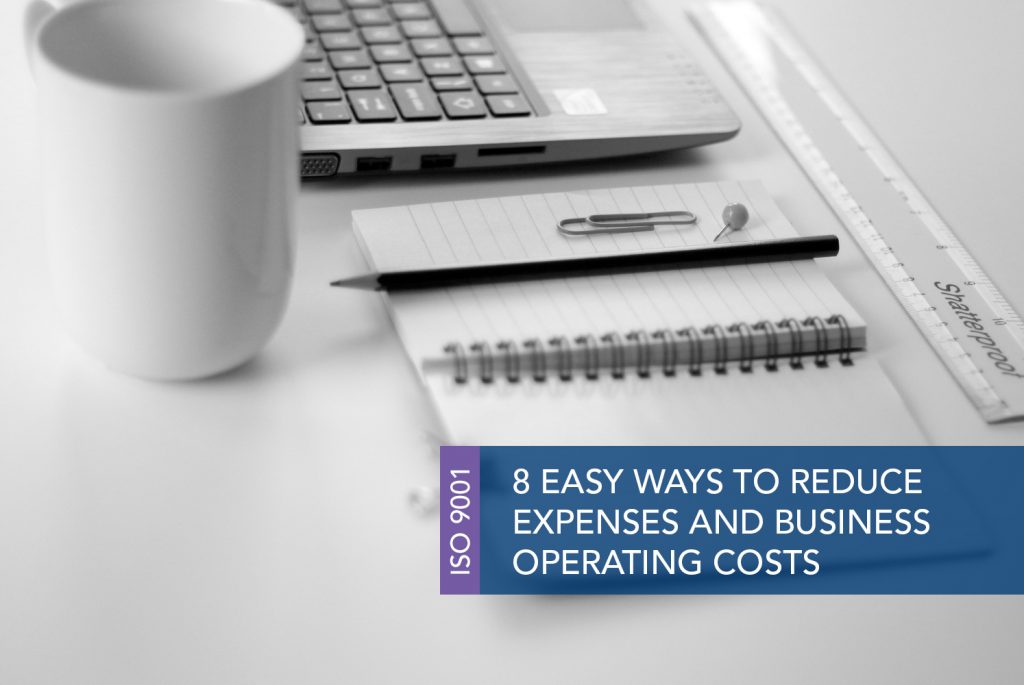 How to reduce expenses and business operating costs MAIN Black and white image of an open notepad next to a computer and a paperclip and pencil lie on top of the notepad