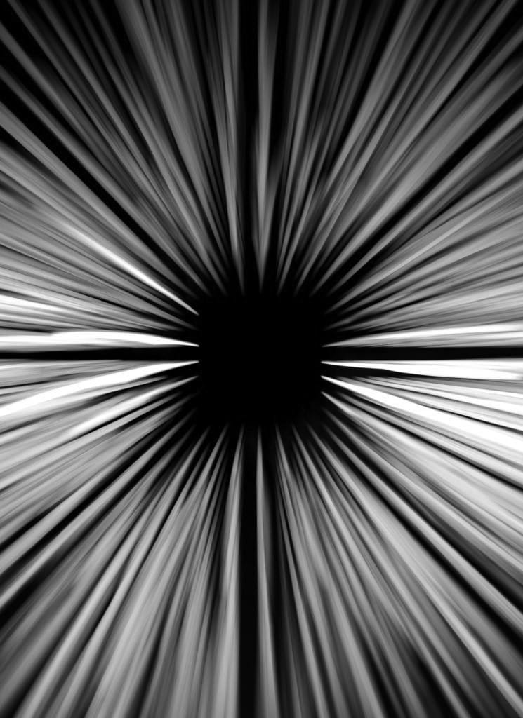 A black square in the middle of the image with black and white streaks surrounding it like and illusion.